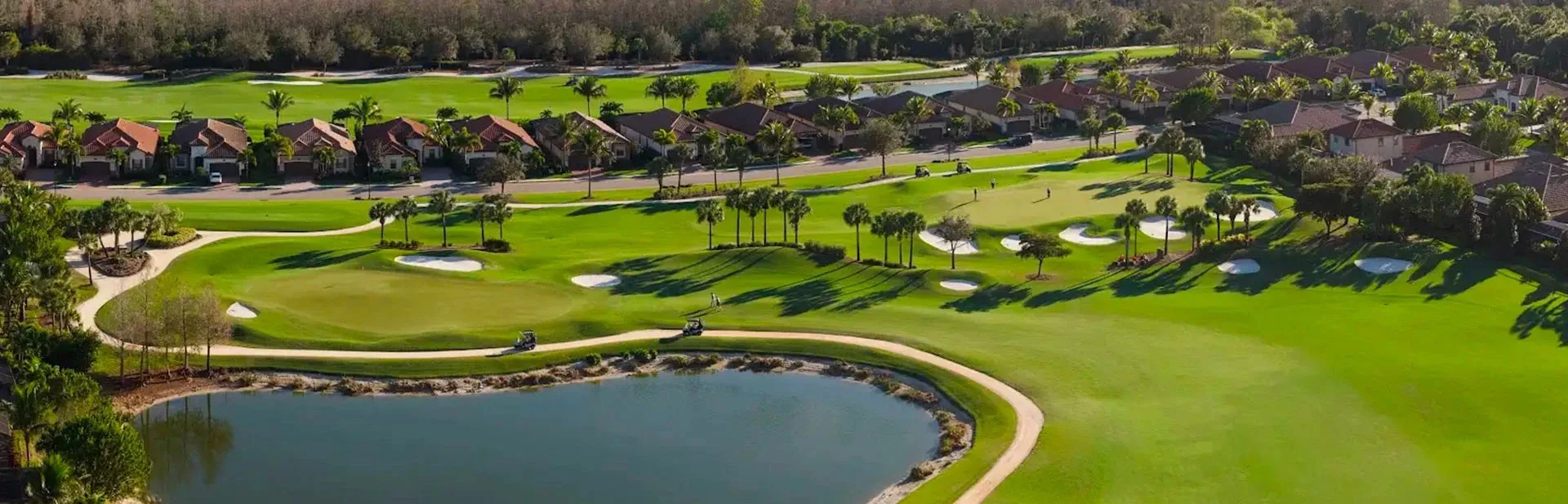 Golf hole and lake with homes beyond at Bonita National.