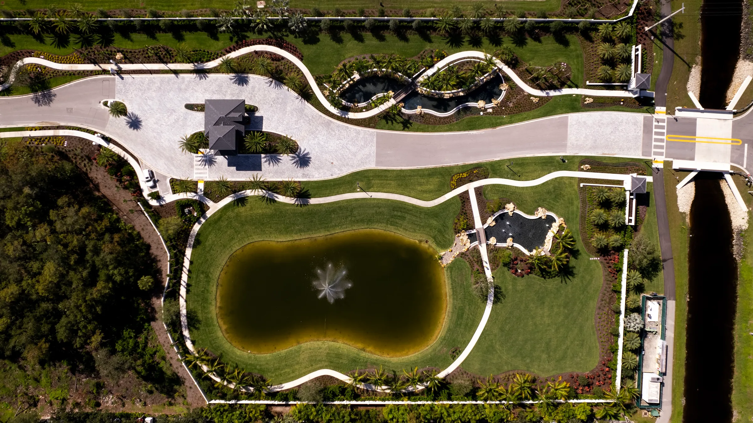 Aerial view of a landscaped lake park and pathways at Caymas, Naples.