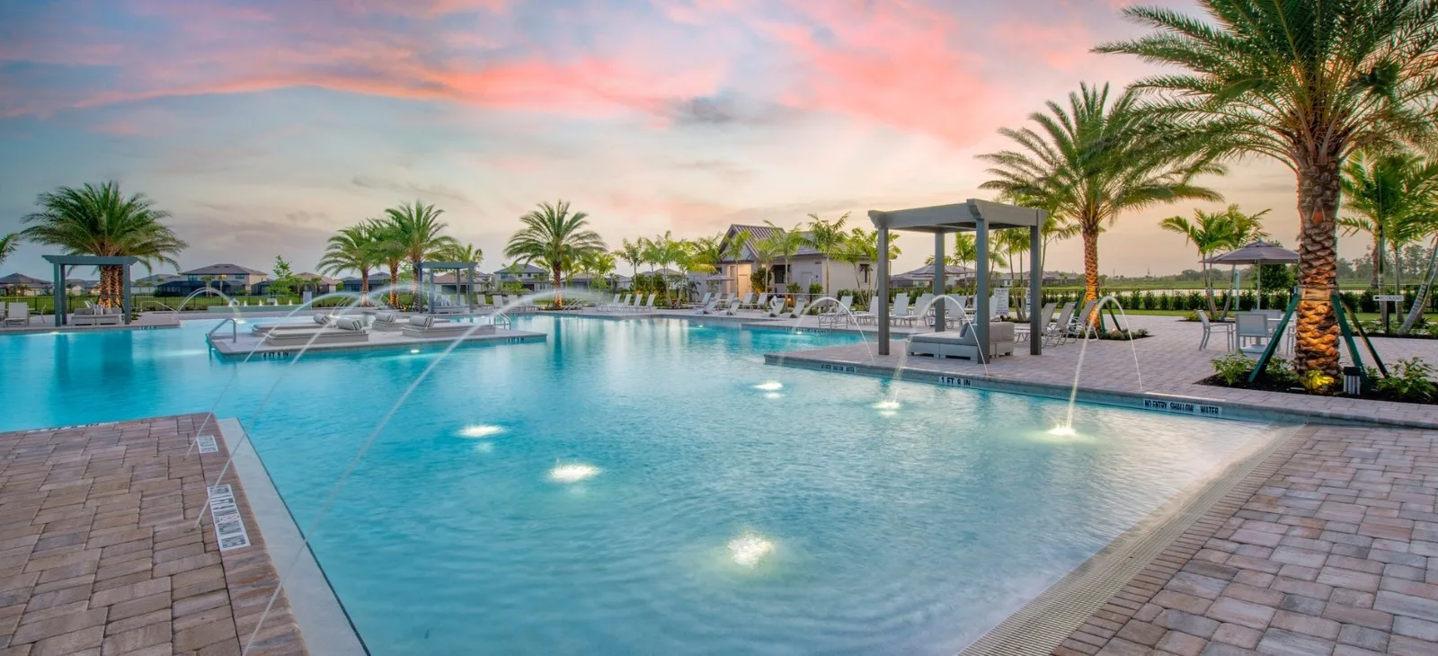 Resort pool with cabanas at the Verdana Village Master Amenity Center at dusk.