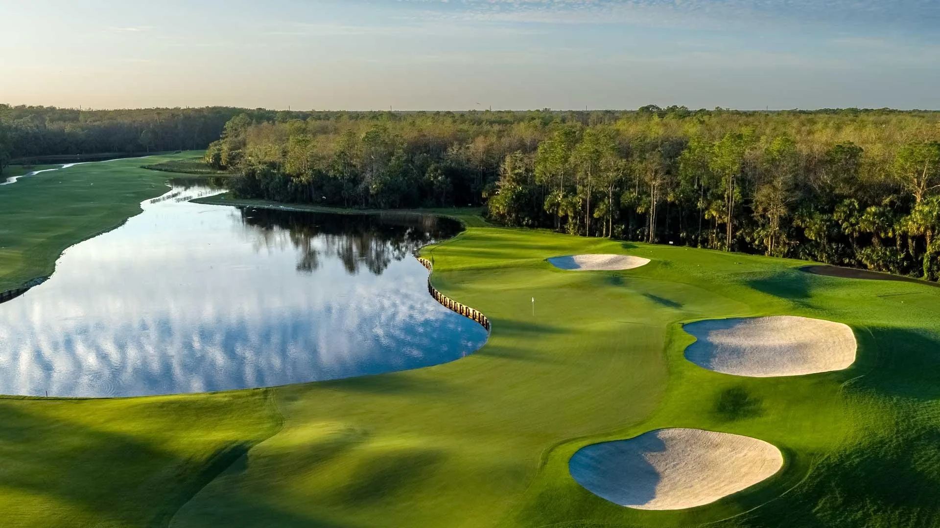 Aerial of a lakeside golf hole with bunkers at Bonita Bay Club, Bonita Springs (official Bonita Bay Club site).