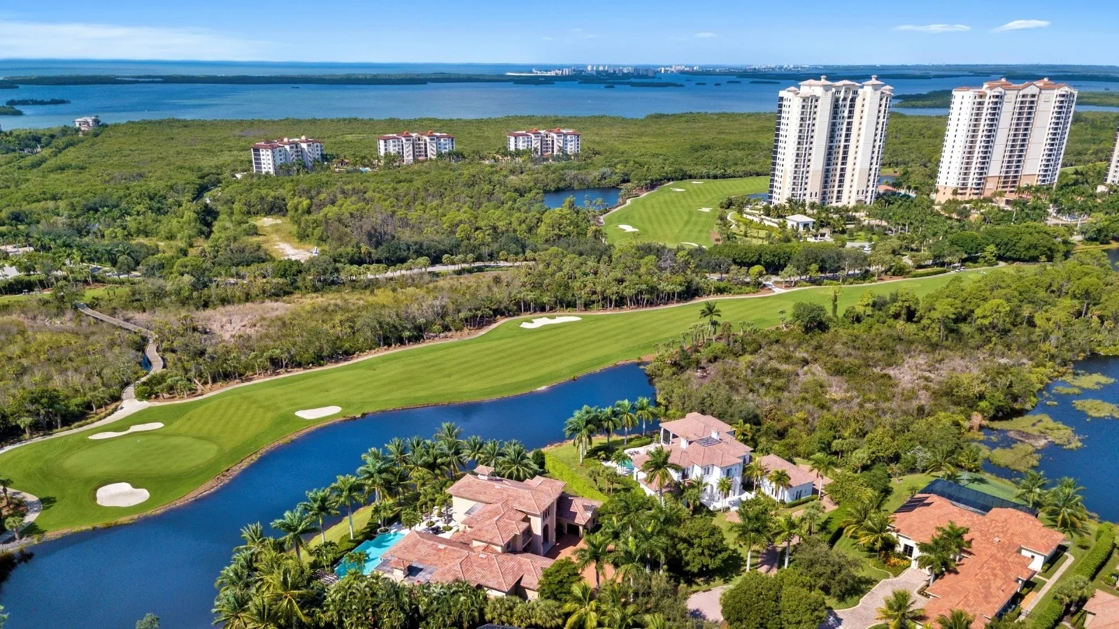 Aerial view of estate homes, golf and high rise towers by Estero Bay, The Colony Golf and Country Club.