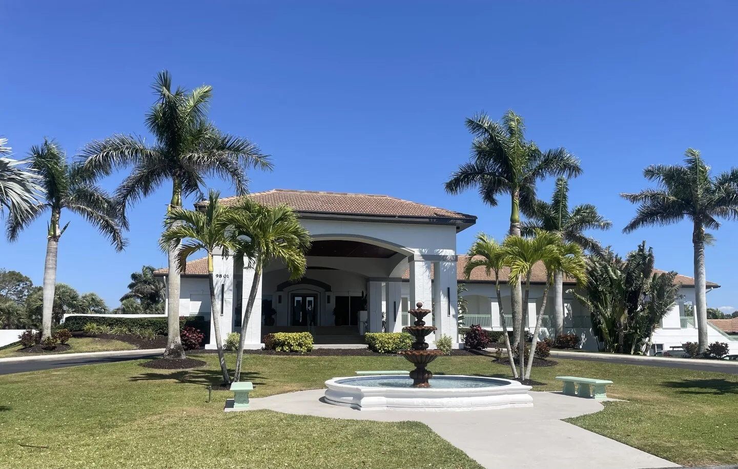 Clubhouse entrance, fountain and palms at Spanish Wells (official).