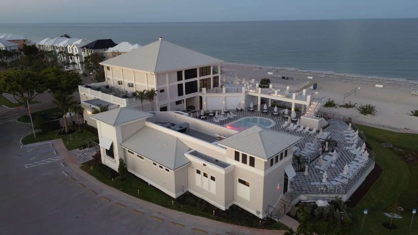 Beachfront resort pool aerial at The Club at Barefoot Beach (official club site).