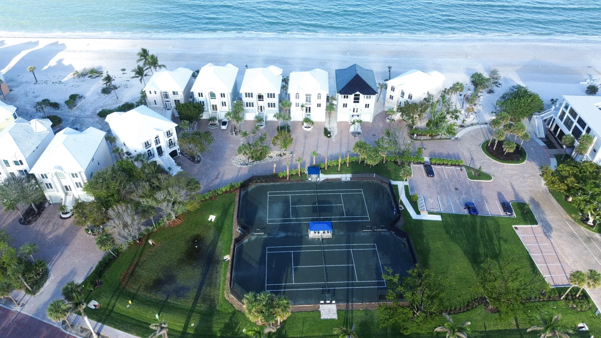 Beachfront homes and tennis court aerial, Barefoot Beach / The Club (official).