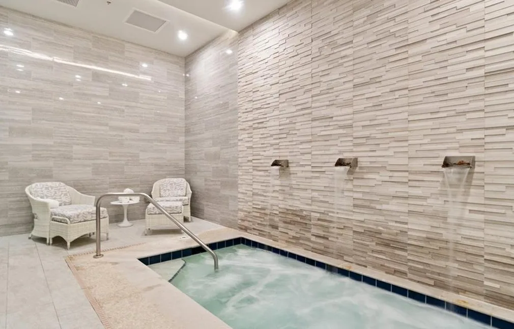 Indoor spa whirlpool with a stone feature wall