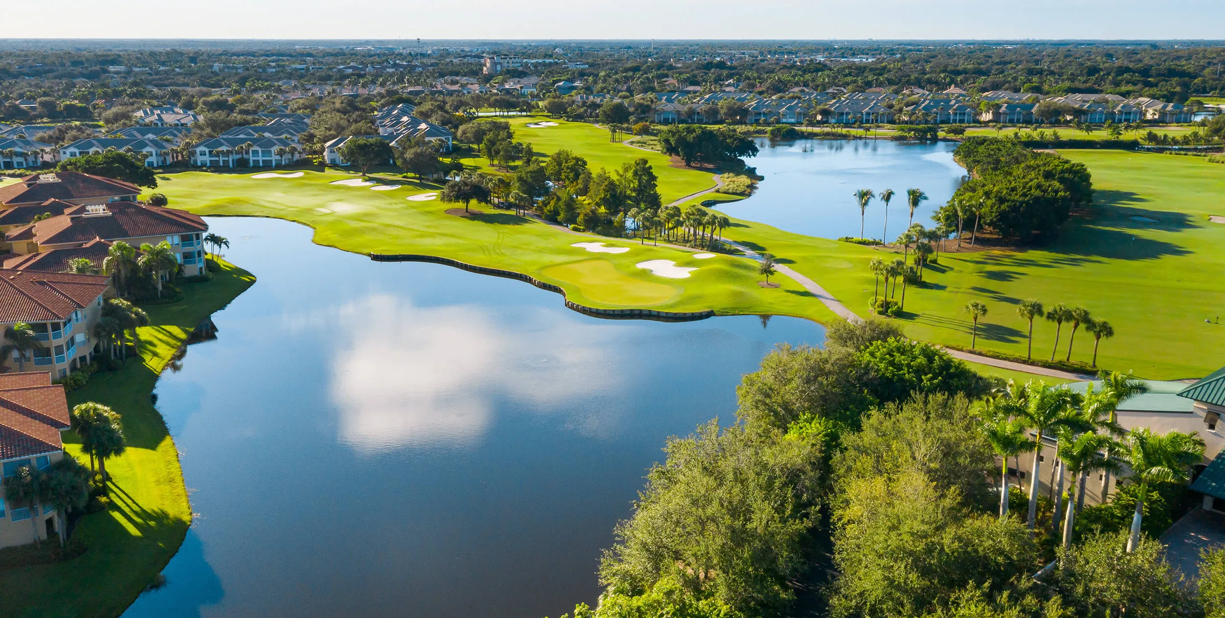 Aerial view of a lake and golf holes at Pelican Marsh Golf Club, Naples.