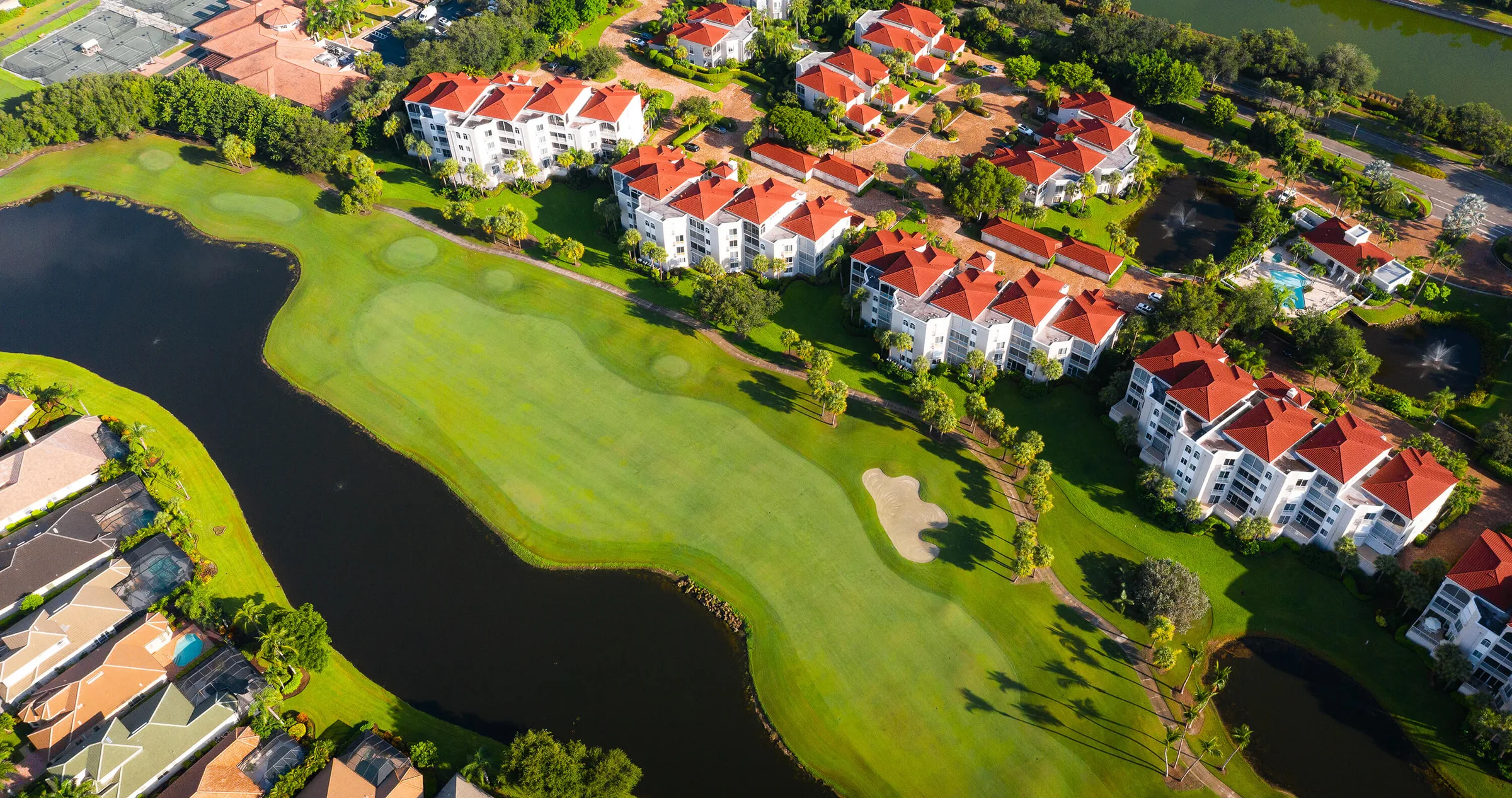 Aerial view of a lakeside fairway and surrounding neighborhoods, Pelican Marsh, Naples.