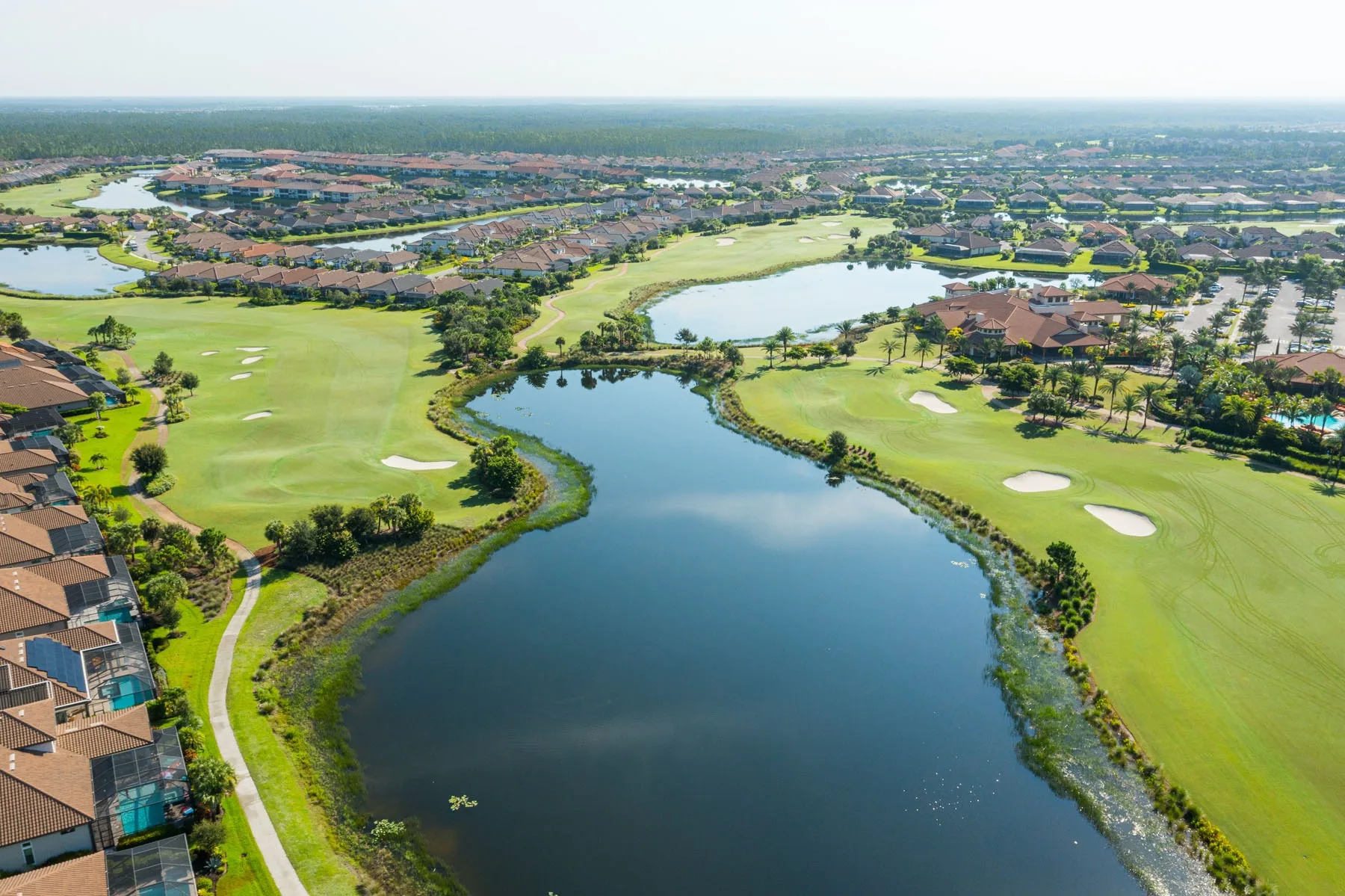 Aerial of a lake-lined golf hole and homes at Esplanade Golf and Country Club, Naples (official club site).