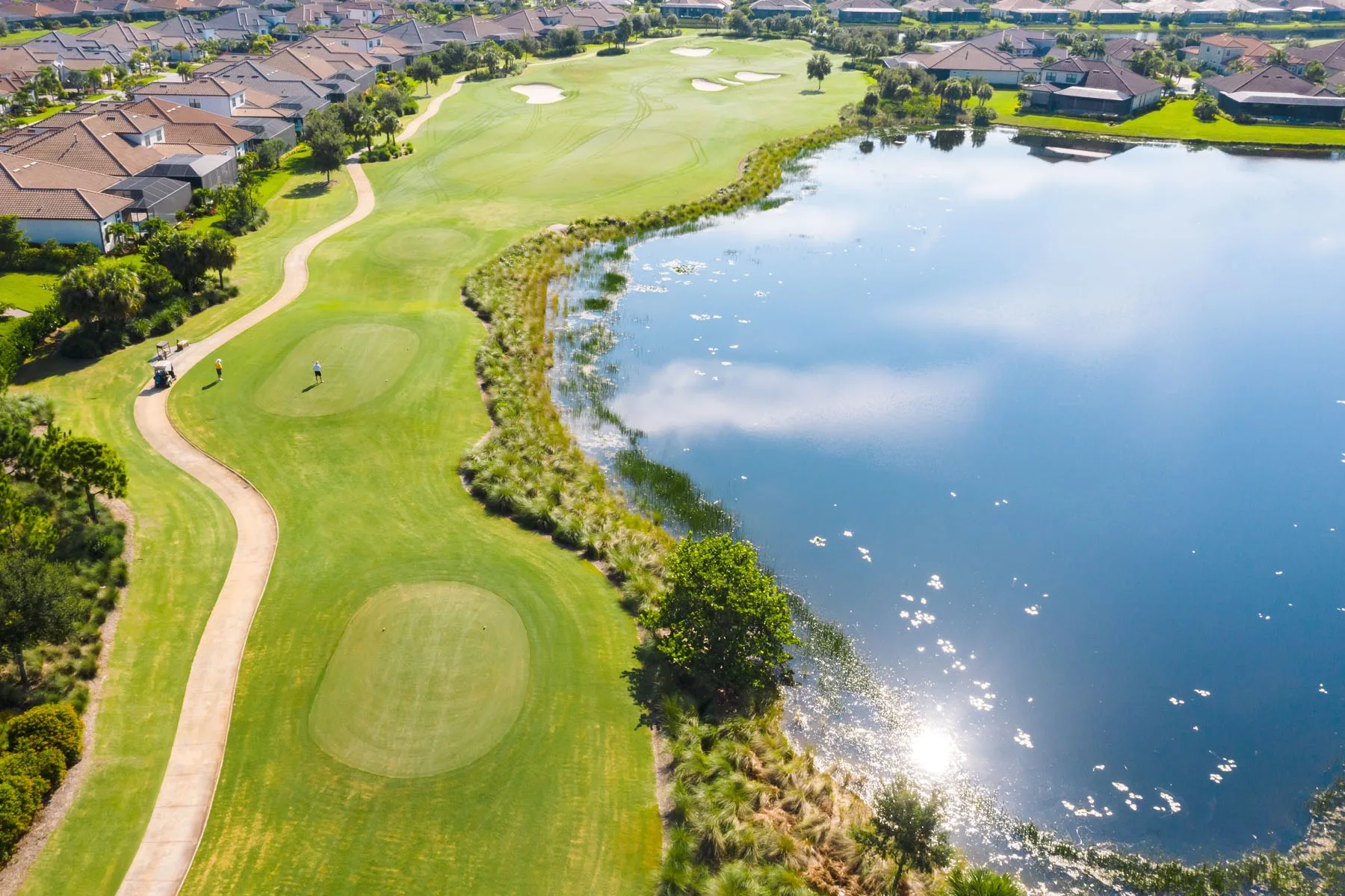 Aerial of a lakeside fairway and green at Esplanade Golf and Country Club, Naples (official club site).