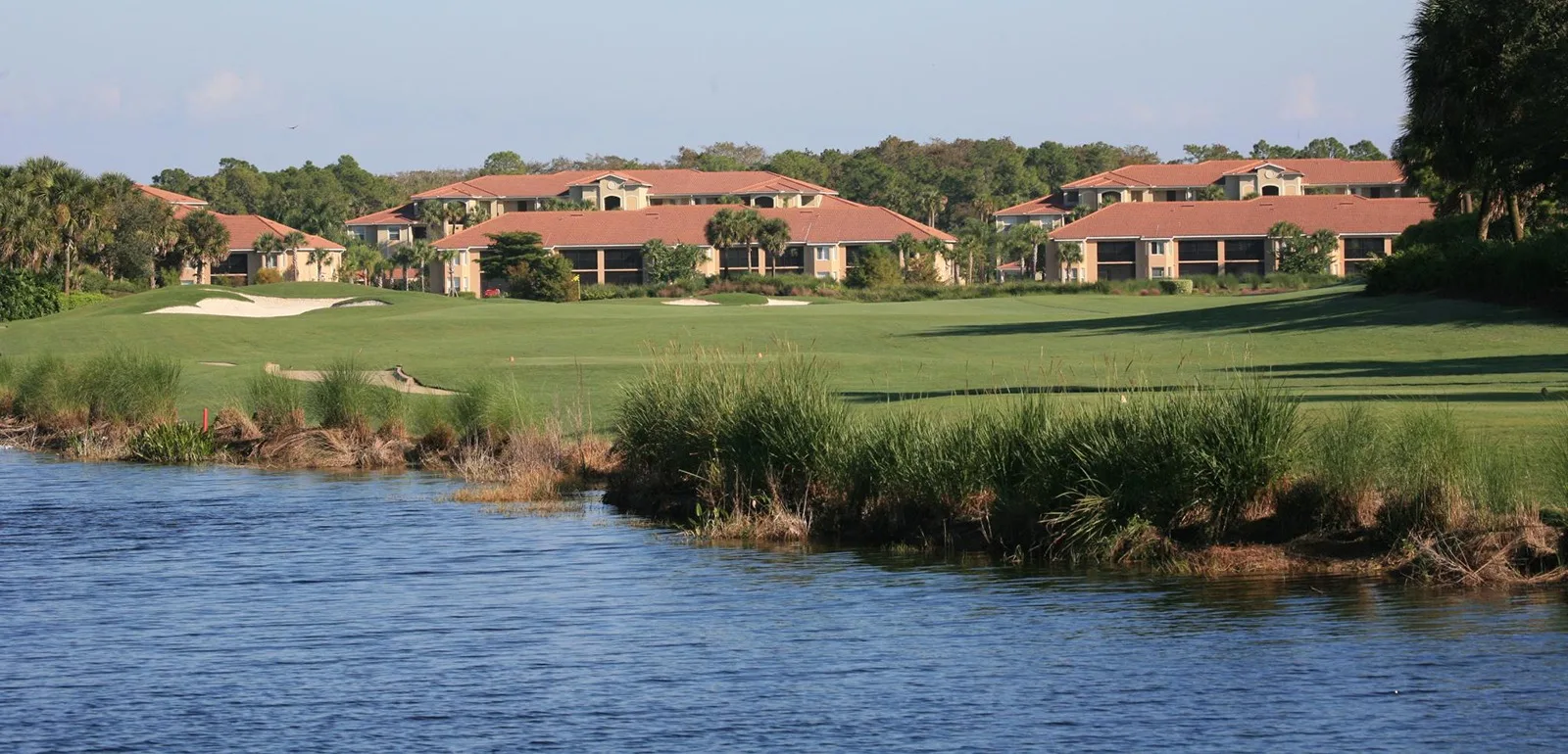 Golf course lake with clubhouse view at Heritage Bay, Naples (official club site).