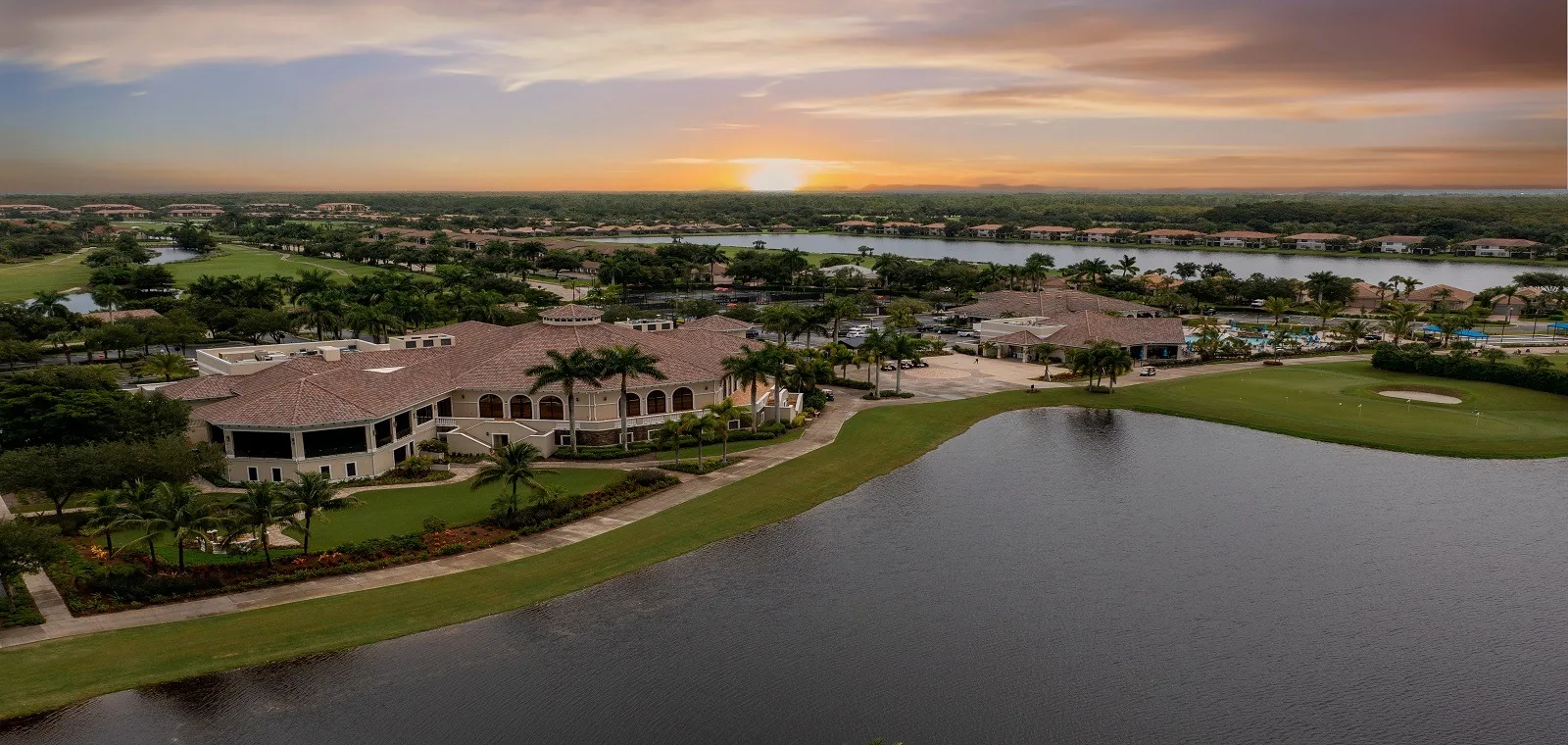 Clubhouse and lake at sunset, aerial view, Heritage Bay, Naples (official club site).