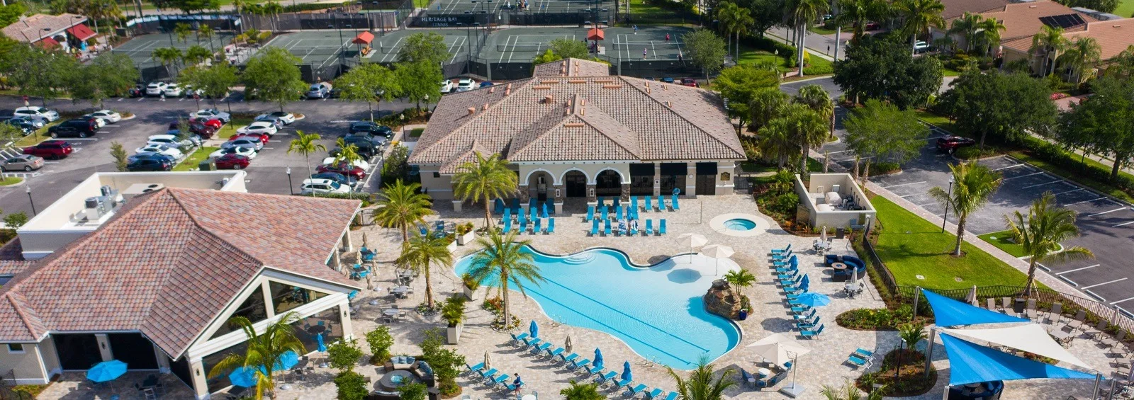 Aerial of the resort-style pool and clubhouse at Heritage Bay, Naples (official club site).