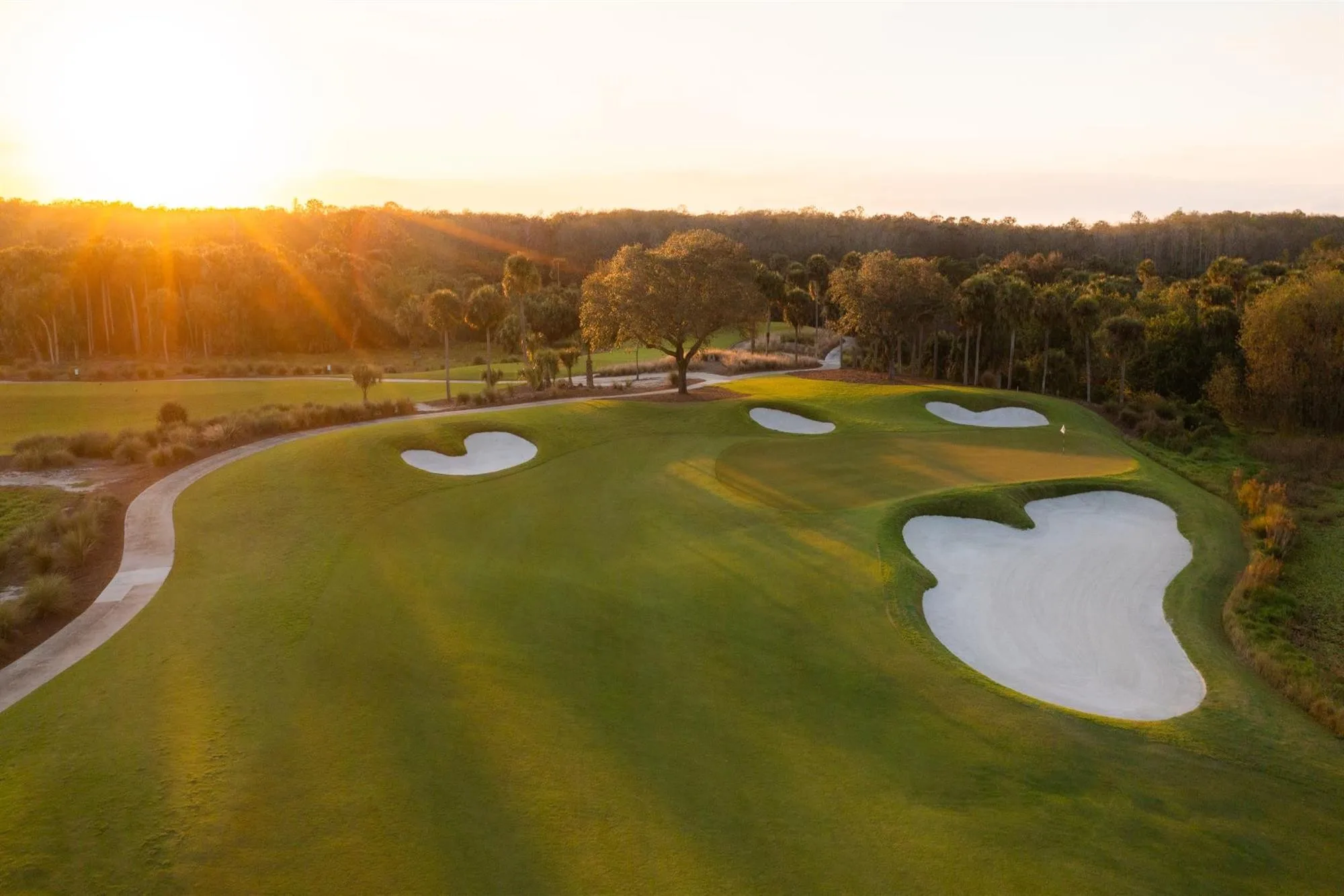 Aerial golf green bunkers at golden hour at TwinEagles Club, Naples (official).