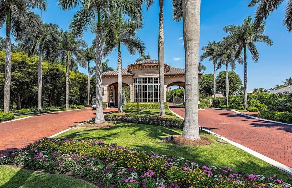 Bay Colony gatehouse with a brick drive and royal palms