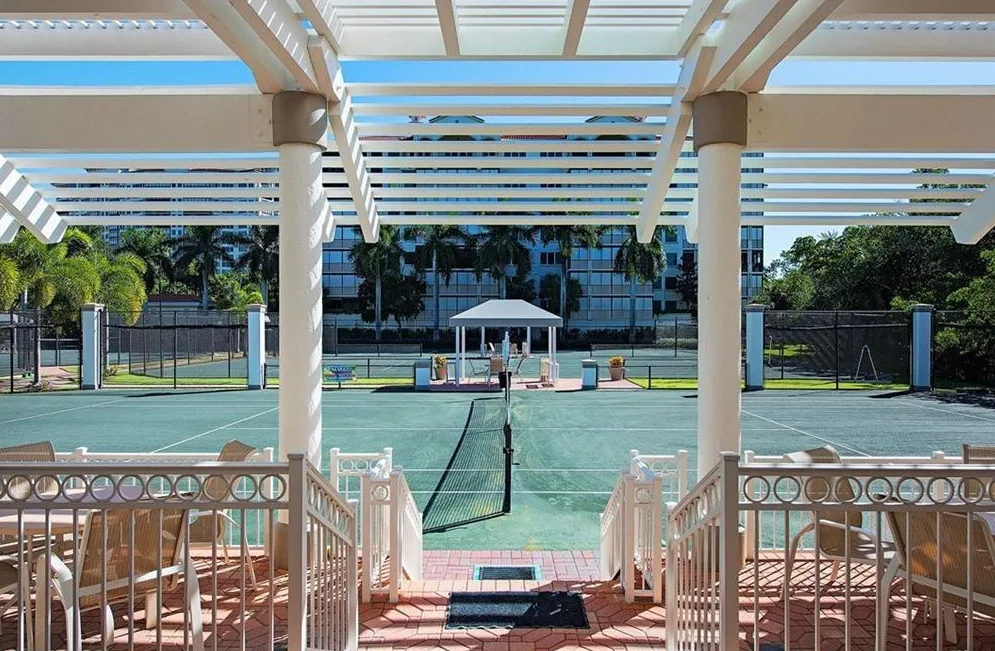 Tennis court viewed from a shaded pergola