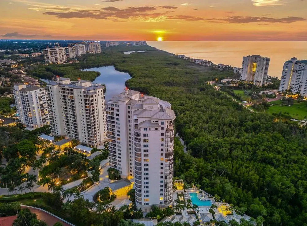 Sunset aerial of high-rise towers along the mangroves and the Gulf in Pelican Bay