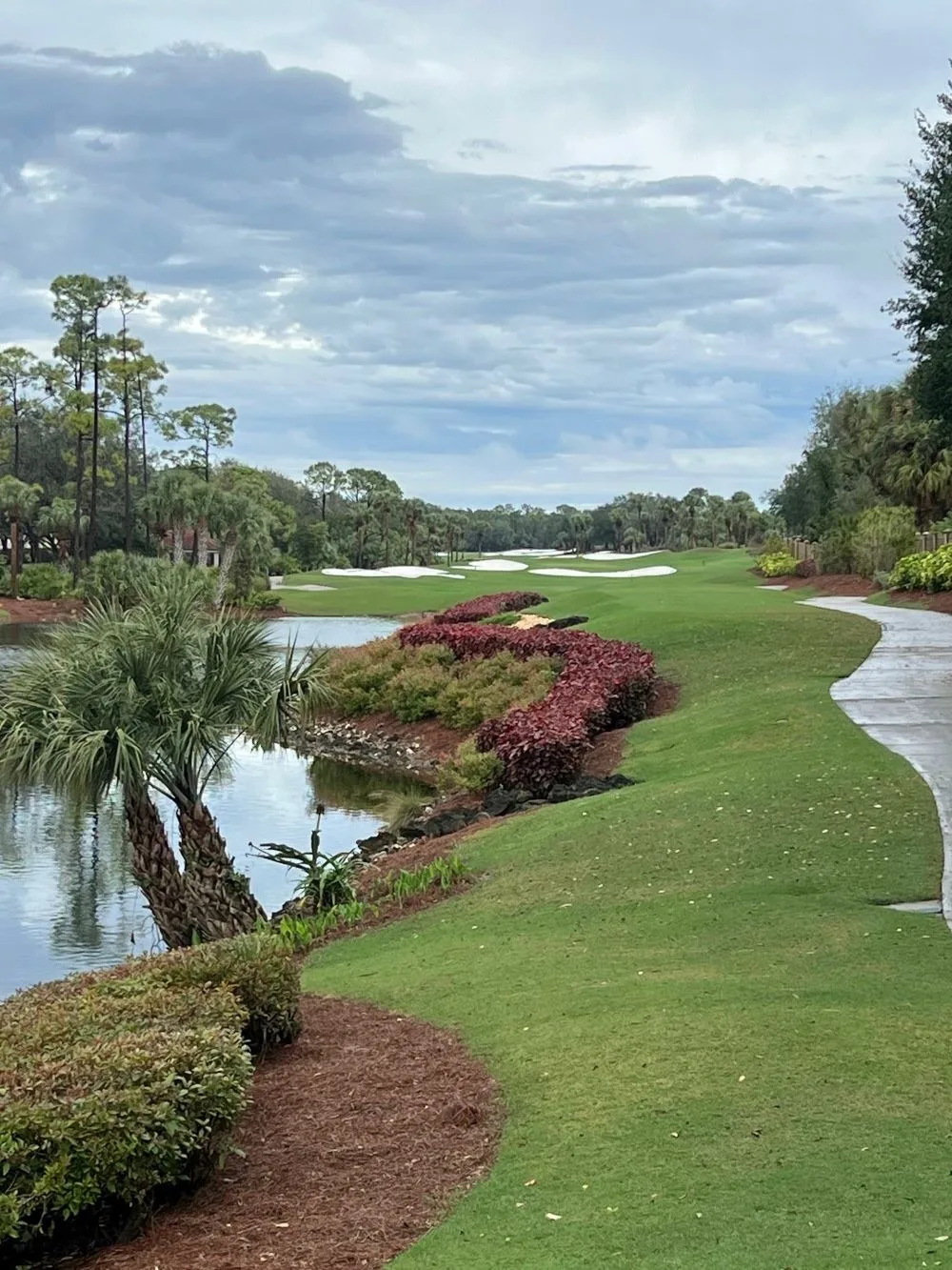 Golf hole along a lake at The Strand, Naples (official club site).