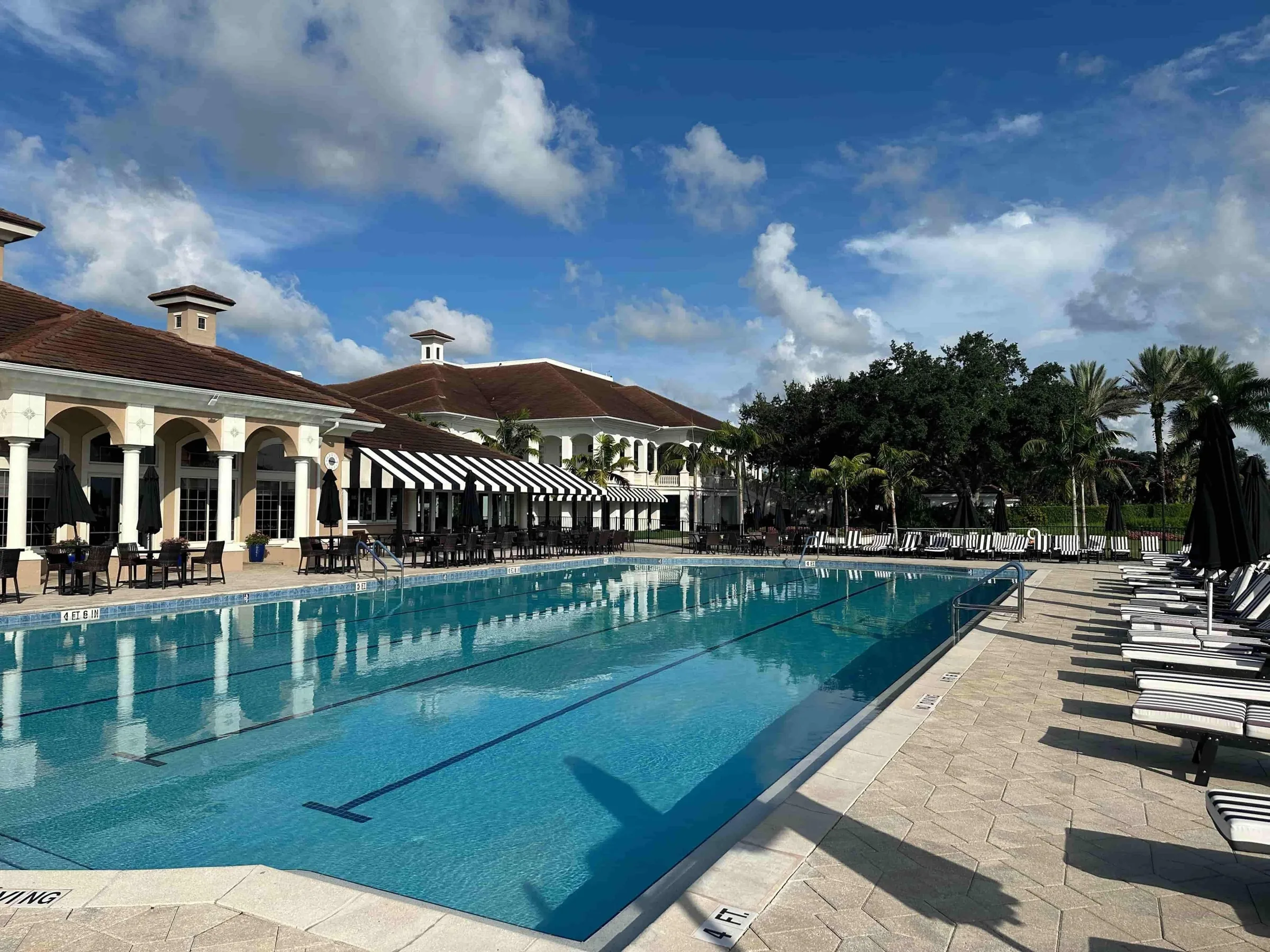 Lap pool and clubhouse at The Strand, Naples (official club site).