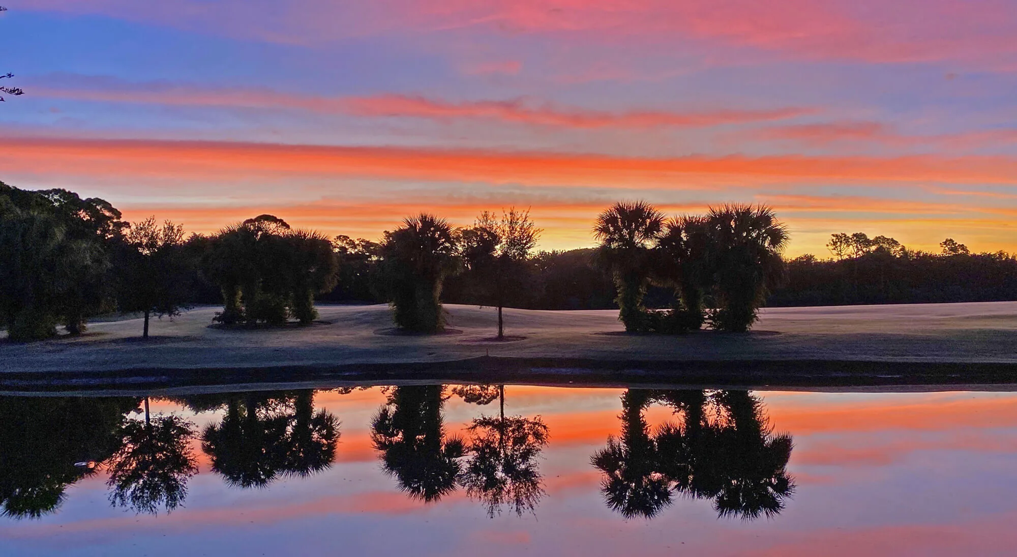 Sunset reflected on a preserve lake at Audubon Country Club, Naples.