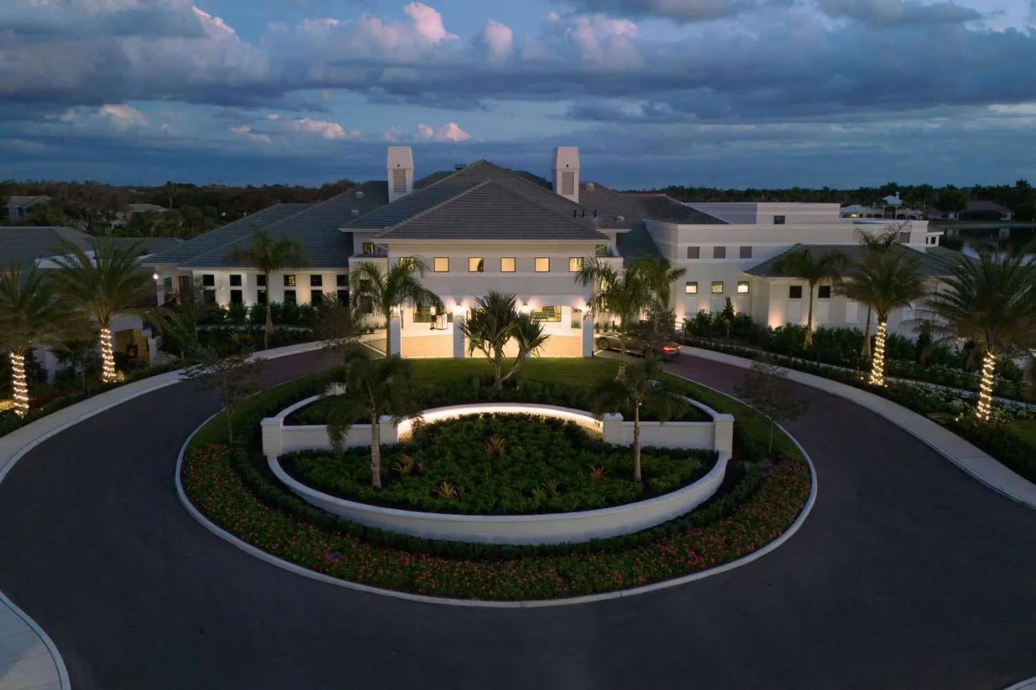 Clubhouse exterior and circular drive at dusk at Kensington, Naples (official club site).