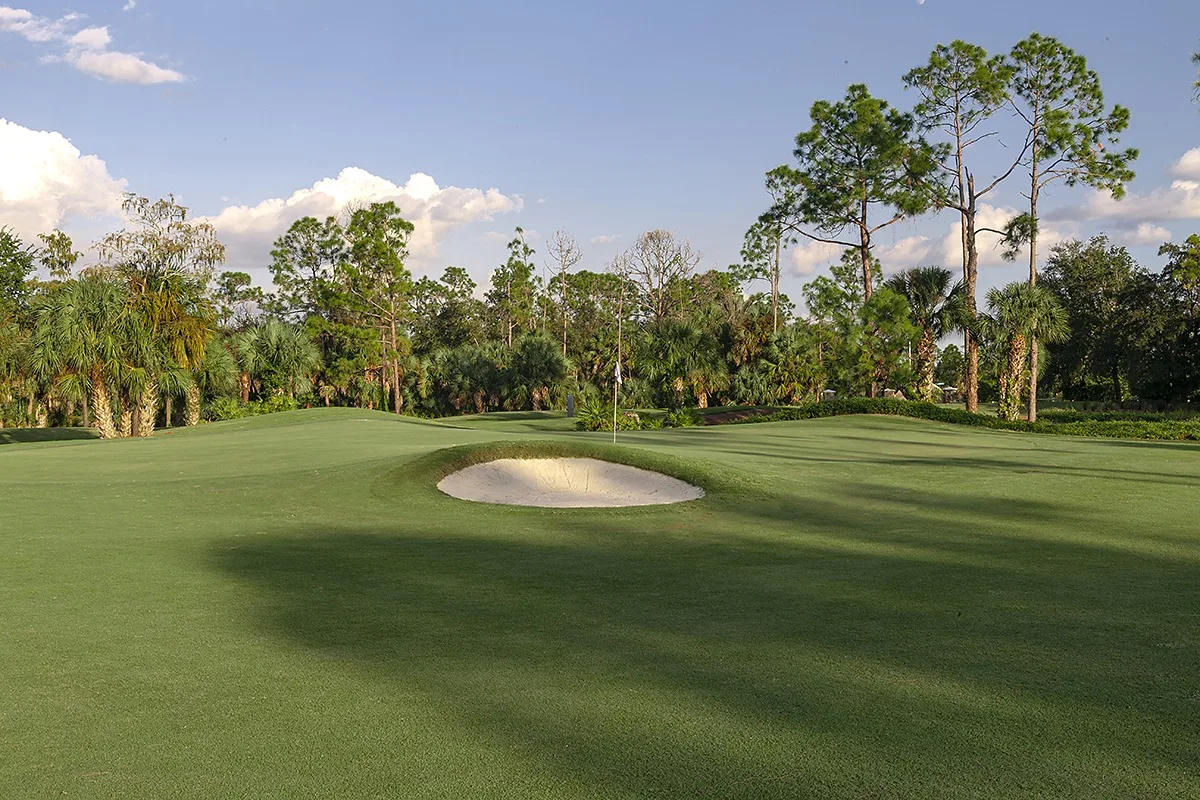 Green framed by palms and bunkers at Valencia Golf and Country Club, Naples (official club site).