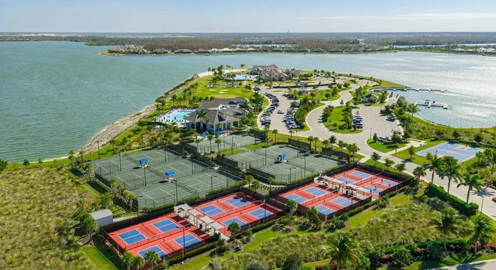 Aerial of WildBlue tennis and pickleball courts, resort pool and clubhouse on the lake