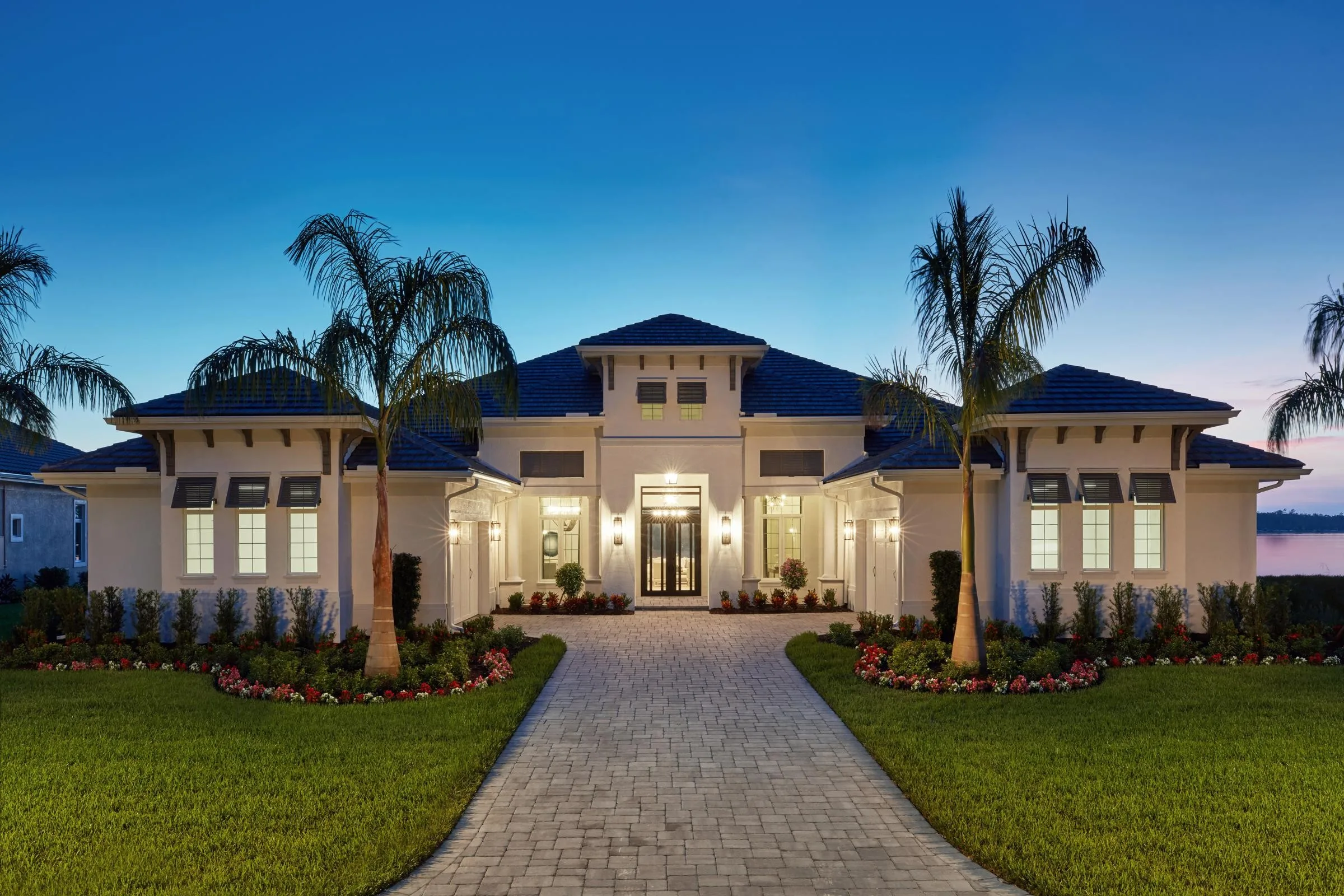 Stock Custom Homes residence exterior at dusk in WildBlue, Estero (official Stock Development photo).