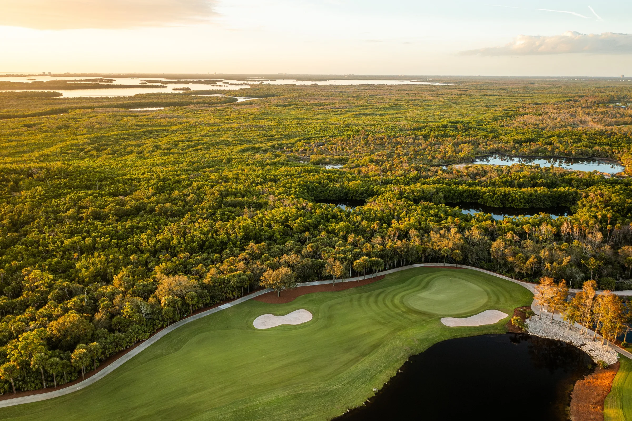 Aerial of a golf hole and preserve at West Bay Club, Estero (official club site).