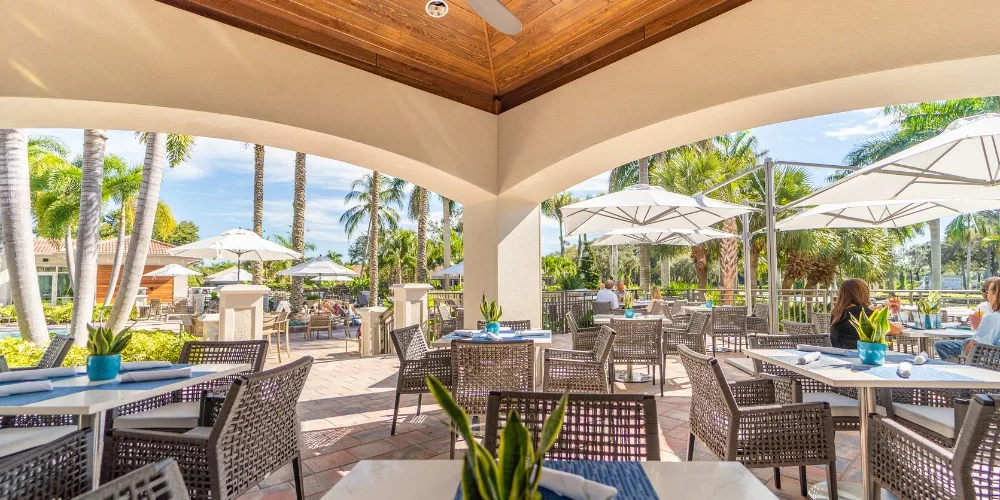 Covered terrace dining at West Bay Club, Estero (official club site).