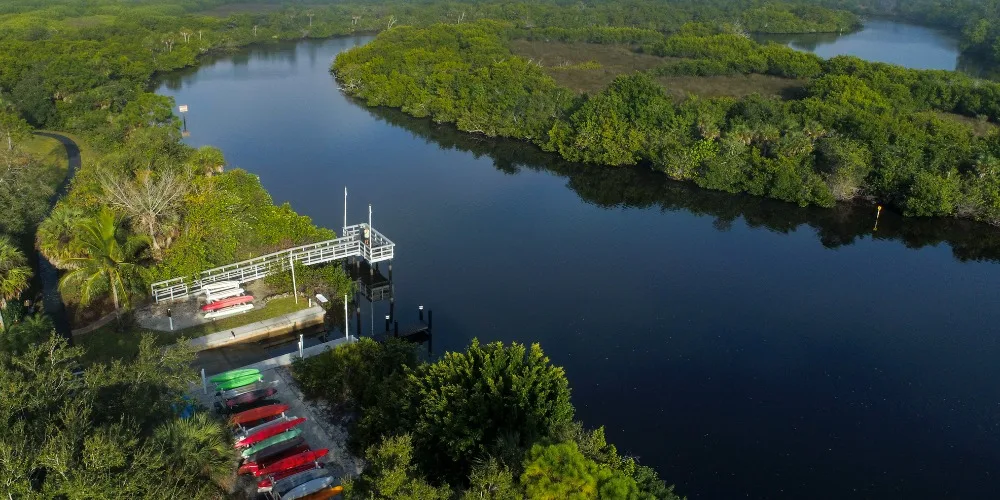 Estero River kayak launch and dock at West Bay Club (official club site).