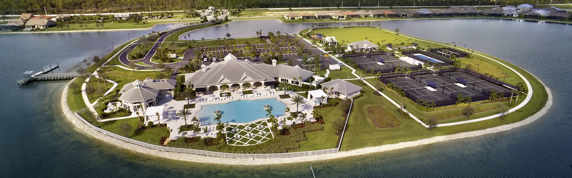 Aerial of the lakefront amenity center on its peninsula at Corkscrew Shores, Estero (official community site).