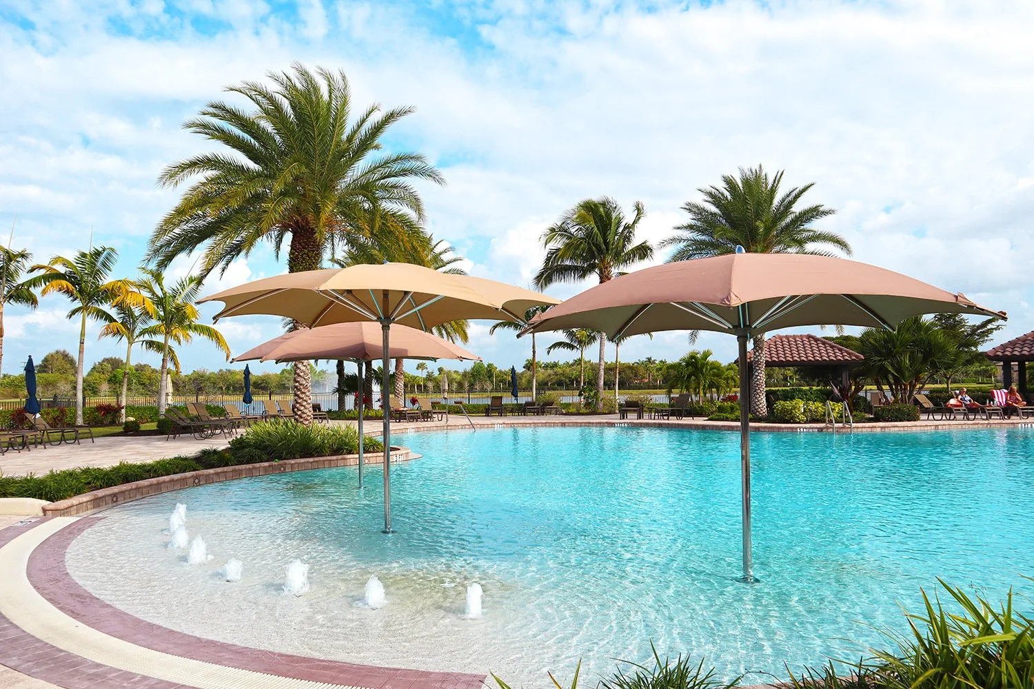 Pool deck with shade umbrellas at The Preserve at Corkscrew, Estero (official HOA site).