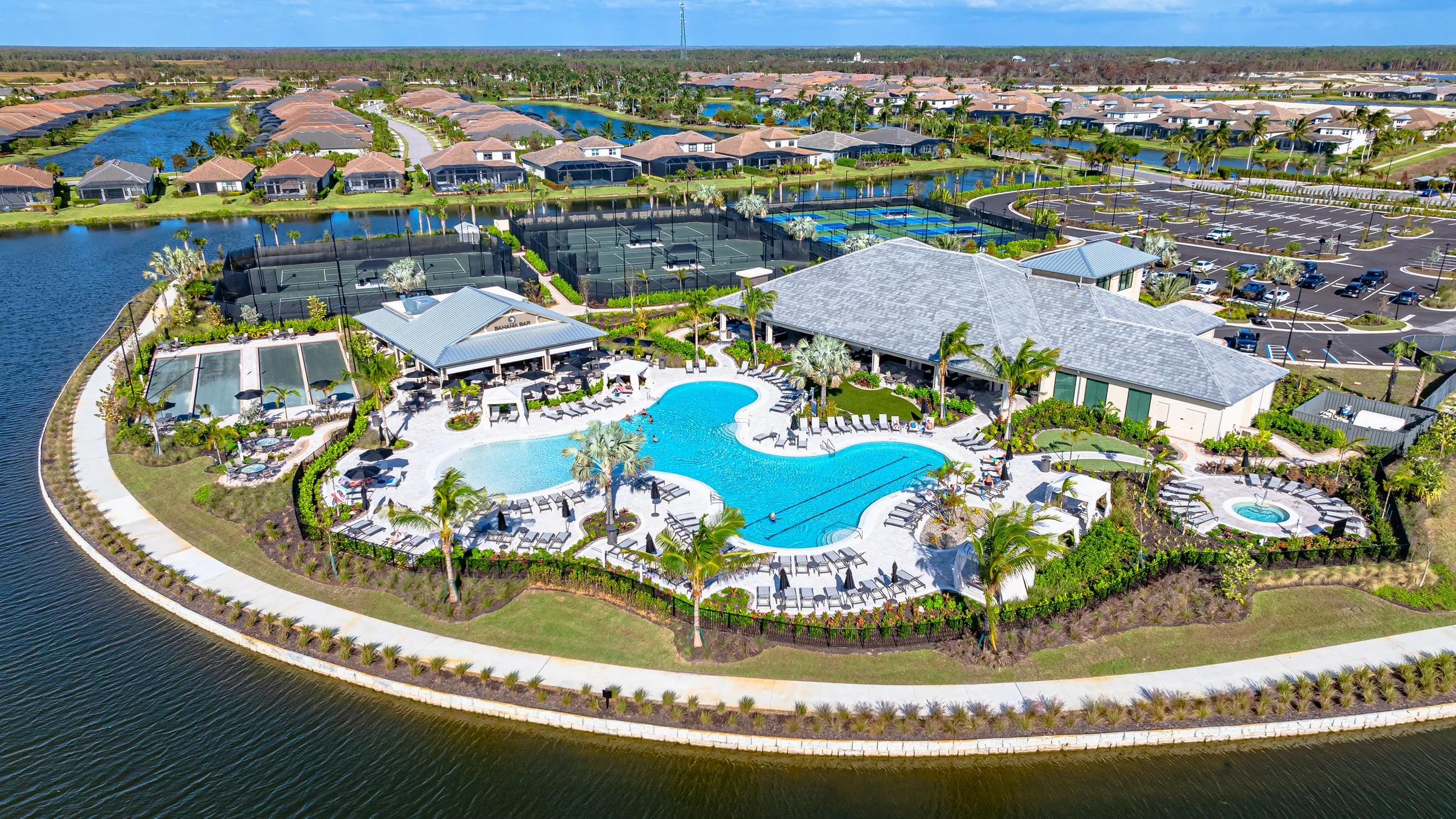 Aerial view of the Wellness and Venue amenity center, resort pool and lakes at Esplanade by the Islands, Naples.