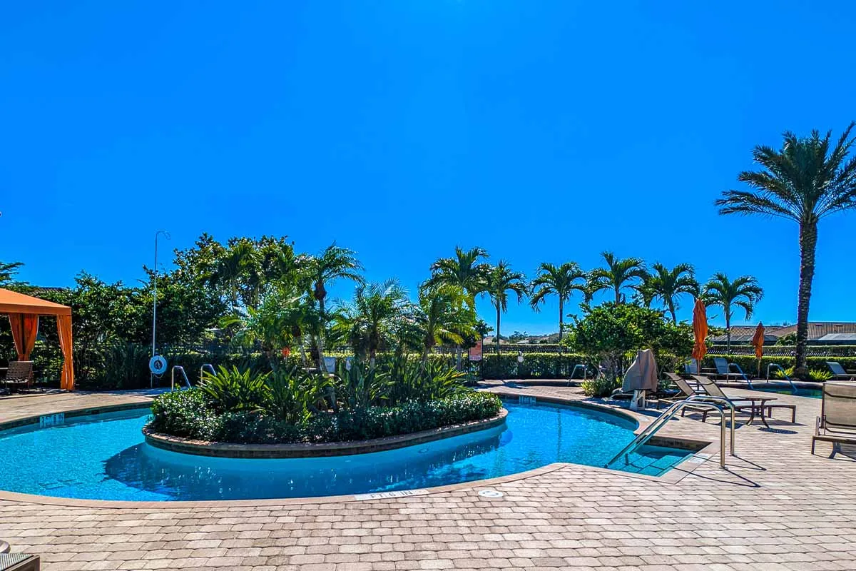 Palm-lined pool deck at Esplanade at Hacienda Lakes, Naples.