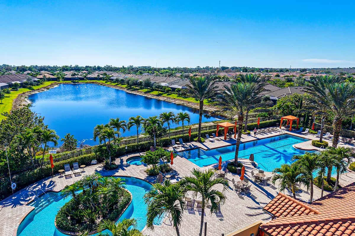 Aerial view of the resort pool beside a lake at Esplanade at Hacienda Lakes, Naples.