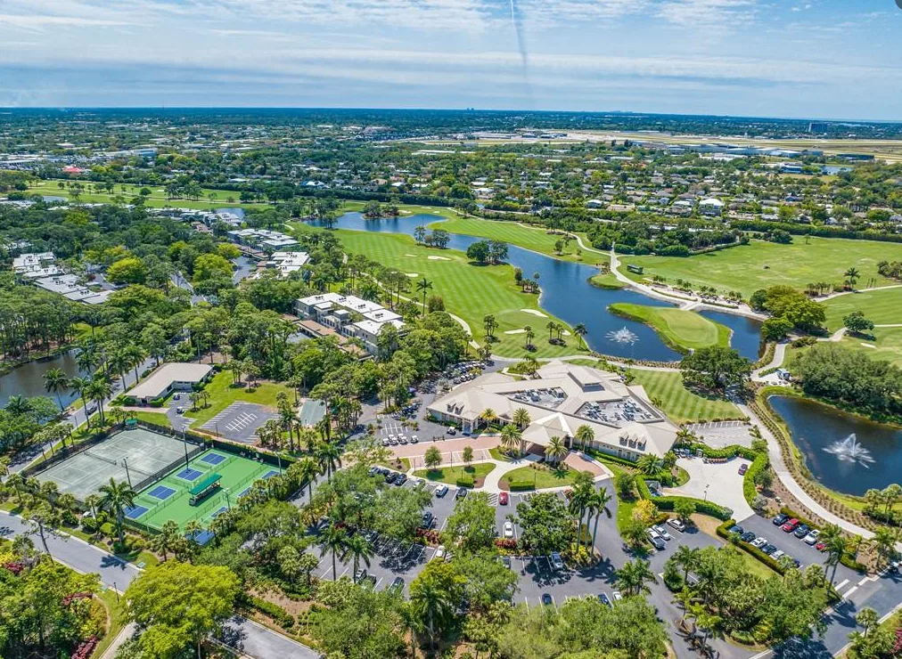 Aerial of the clubhouse, tennis and pickleball courts, golf course and lake at Bear's Paw