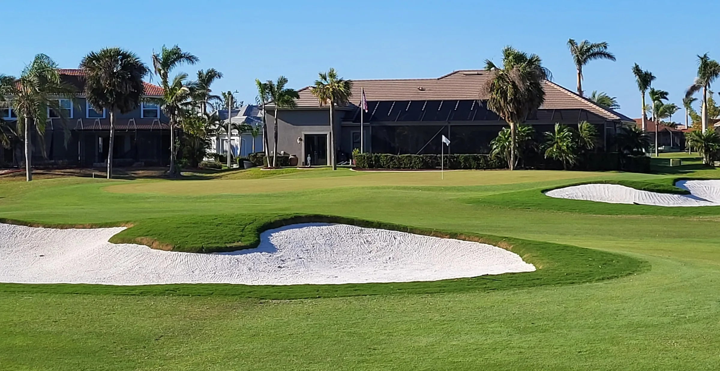 Green-side bunkers with the clubhouse beyond at Cape Royal Golf Club, Cape Coral (official club site).
