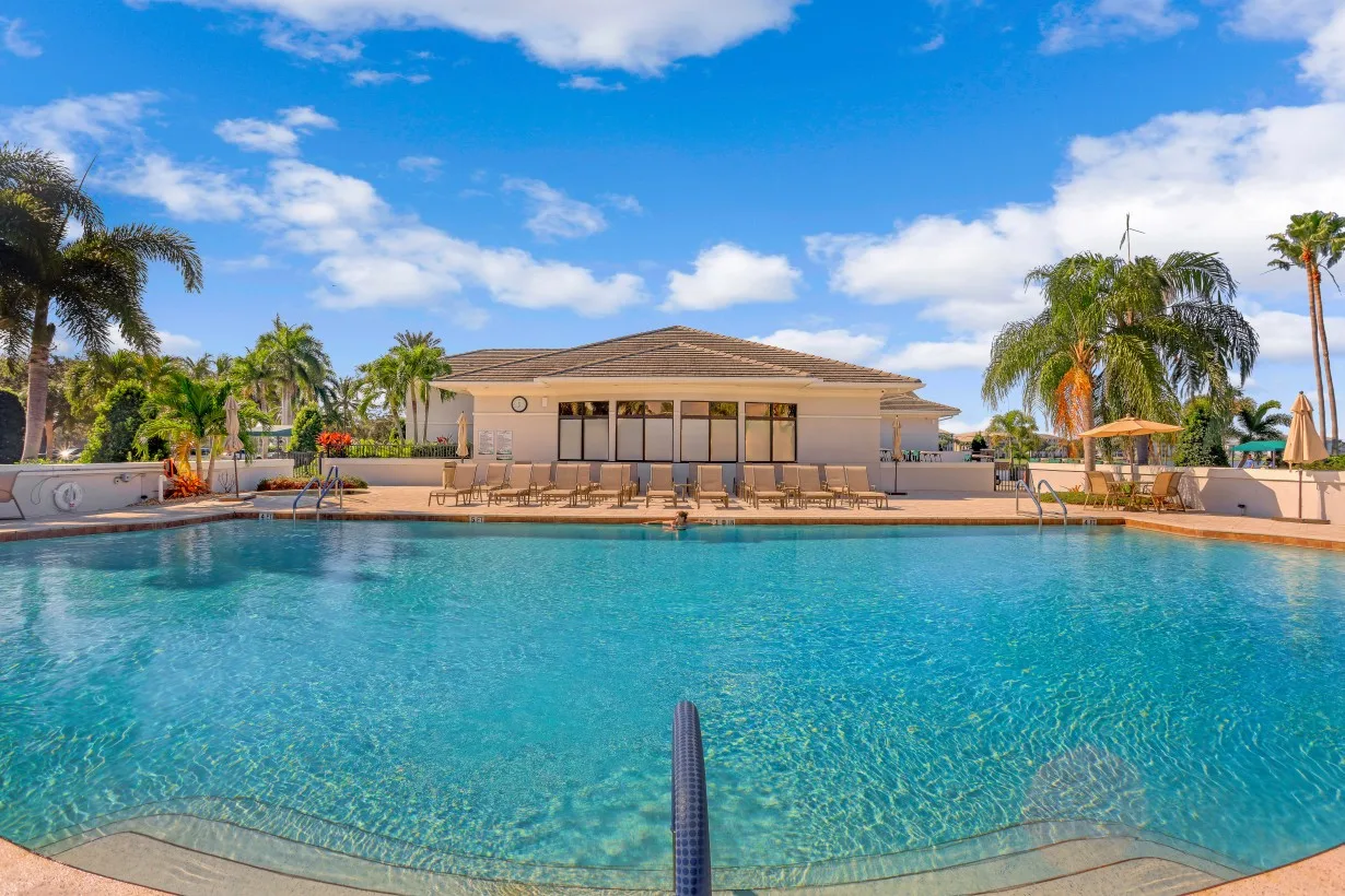 Community pool with clubhouse beyond at Heritage Palms (official).