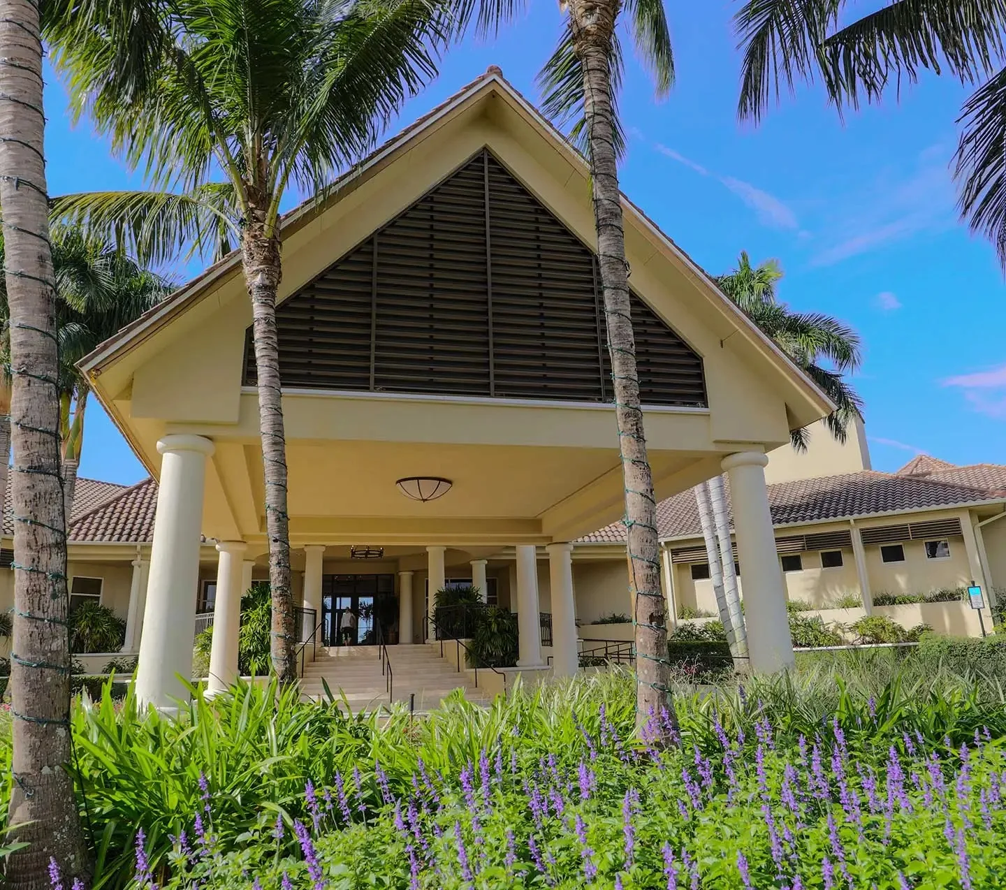Clubhouse entrance with tropical landscaping at The Plantation, Fort Myers (official club site).