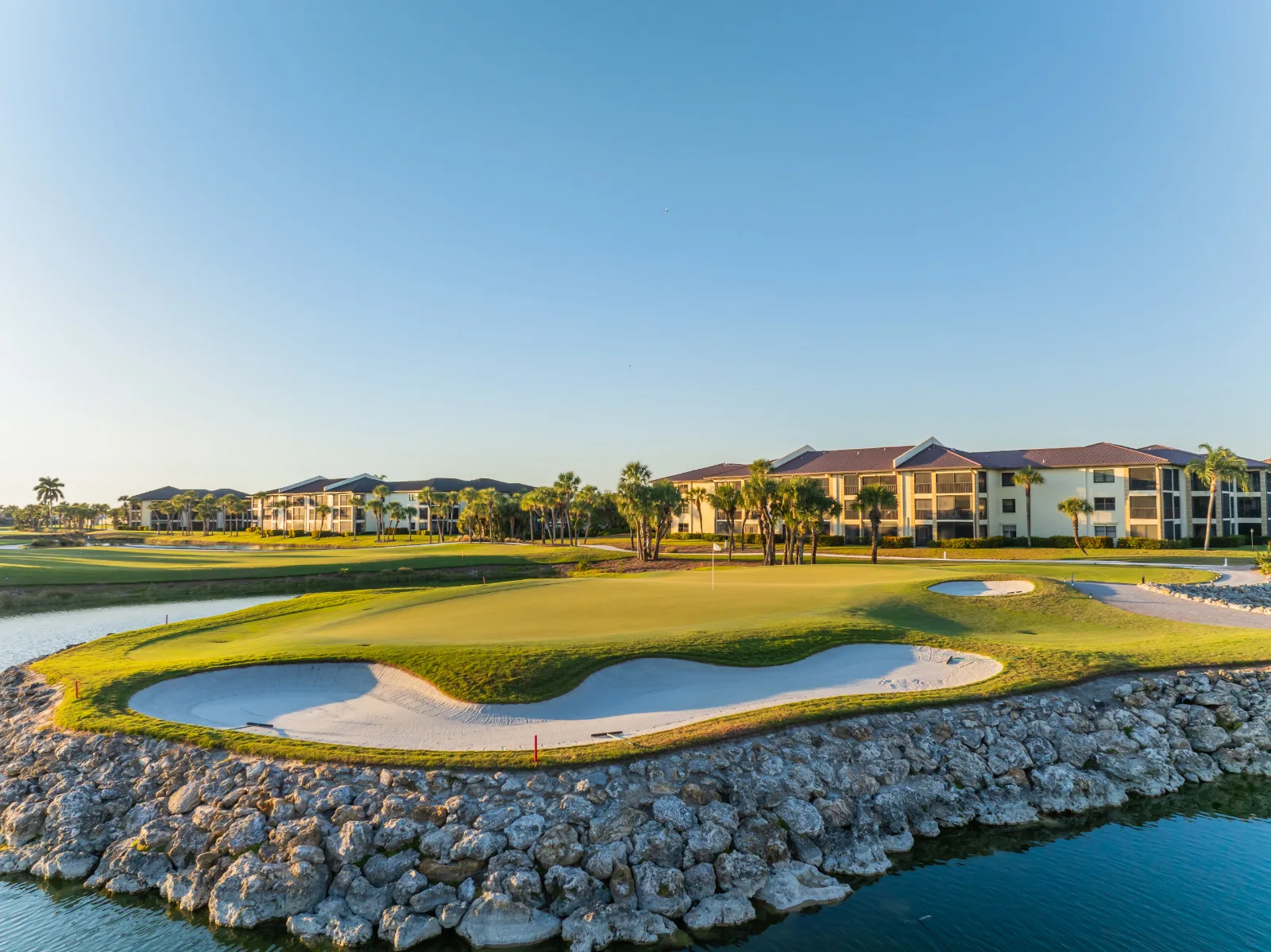 Bunker and green beside the water at Kelly Greens (official club site).