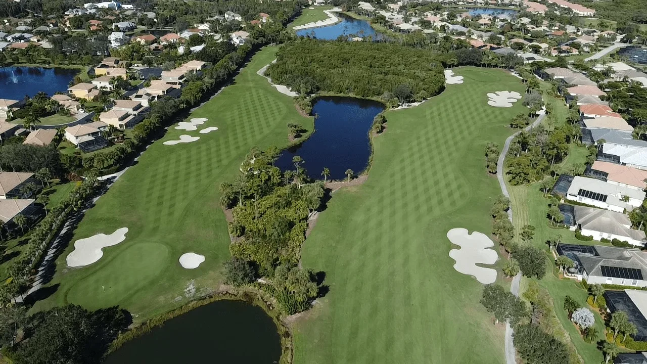 Aerial of lake-lined golf holes at The Golf Club at Crown Colony, Fort Myers (official community and club sites).