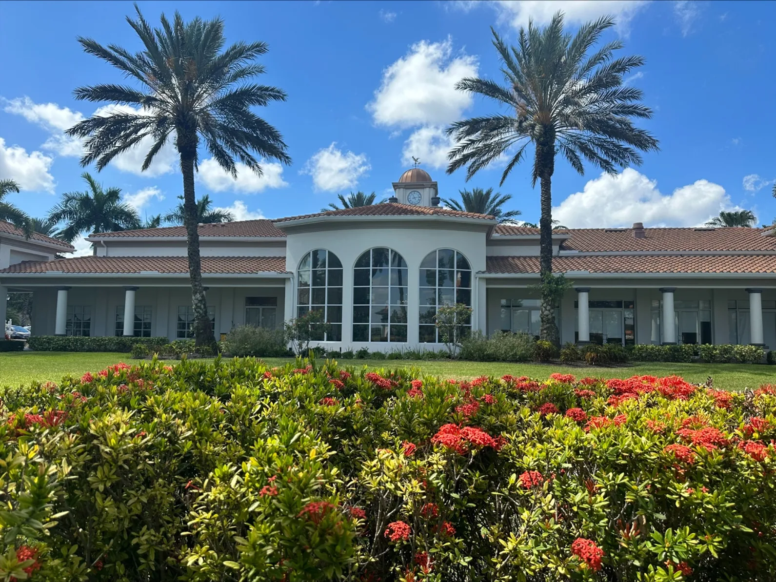 Town Center building framed by palms and flowering shrubs at Island Walk, Naples.