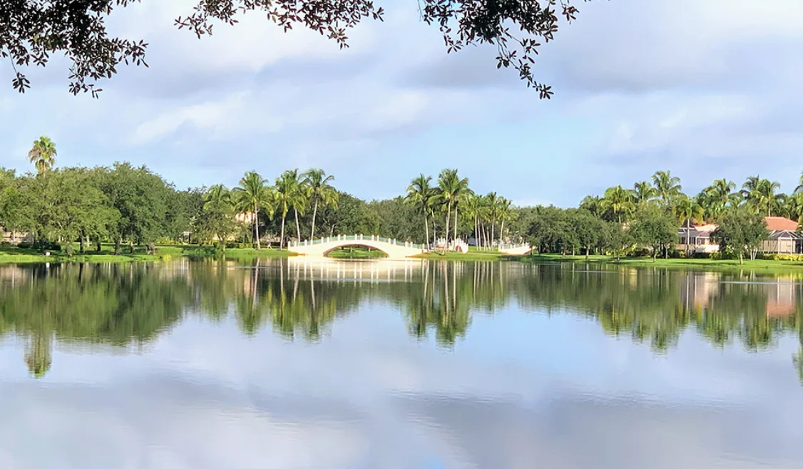 Lake and arched footbridge at Island Walk, Naples.
